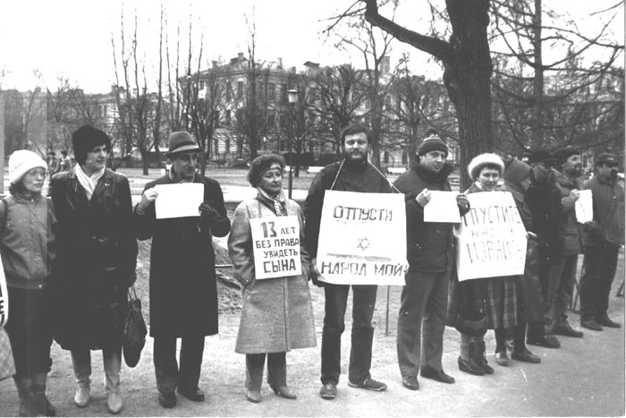 Демонстрация отказников у въезда на территорию зданий обкома и горкома КПСС
(бывший Смольный Институт).
23 Апреля 1987, Ленинград.
Слева направо:
1. Елена Кейс 2. Лиля Шапиро 3. Владимир Кнох 4. Римма Сосна 5. Борис Локшин
6. Марк Будняцкий 7. ? 8. Елена Долганова 9. Виктор Долганов 10. Евгений Лейн 11. ? .
Всего в демонстрации приняло участие 23 человека.
(Из фонда Владимира Лифшица)