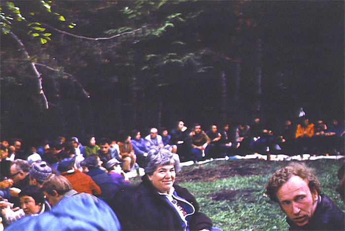 Десятая годовщина Шестидневной войны, 1977 год.
Народу собралось много, Доклад Аркадия Май был очень толково составлен. Рассказ вызвал большой интерес у слушателей. Ему задали много вопросов, так как в деталях мало кто знал историю войны. На переднем плане, крупно &mdash; Циля Ройтбург-Менджерицкая. Её семья активно участвовала в жизни московской алии. Дом Цили и её мужа Милана был местом важных встреч в процессе нашей долгой борьбы за выезд. Вы видите, что слушатели сидят на бревнах и перед ними белая полоса &mdash; это играющие роль скатерти листы компьютерных распечаток. В песне об «Овражках» поётся: «Мы раскатаем на траве „столы"/ Лехаим скажем,/ Улыбнемся взглядом.“ &mdash; это те самые „столы“ из распечаток.