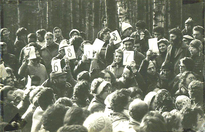 3-й фестиваль еврейской песни, 1980&nbsp;г., другая часть поляны.
На бревне сидят члены жюри, оценивая уровень исполнения по десятибалльной системе. Слева направо: Мика Членов &mdash; держит оценку 7; Натан Шварцман &mdash; с оценкой 7; Зеэв Престин &mdash; с оценкой 6; Лена Чернобыльская &mdash; держит 8; Наташа Розенштейн &mdash; держит чистый лист; Элиягу Эссас &mdash; 7; Арон Гуревич &mdash; 8; Паша Абрамович &mdash; 7. Рядом с Пашей стоит отказник Саша Этерман, нынешний экономический обозреватель радиостанции на русском языке. Девушка в очках справа от Саши &mdash; отказница Хана Магарик.